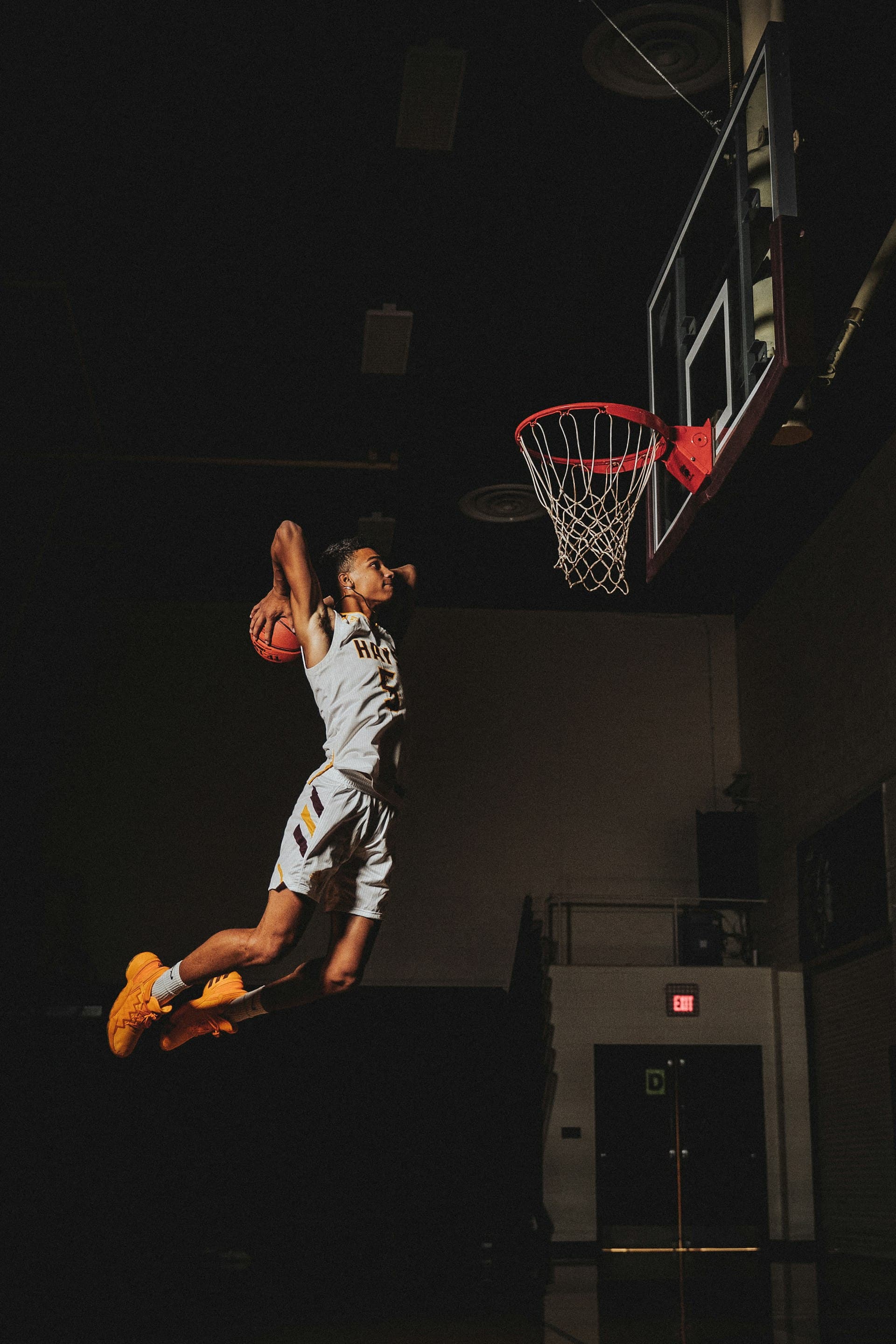 Dark basketball court illuminated by spotlights